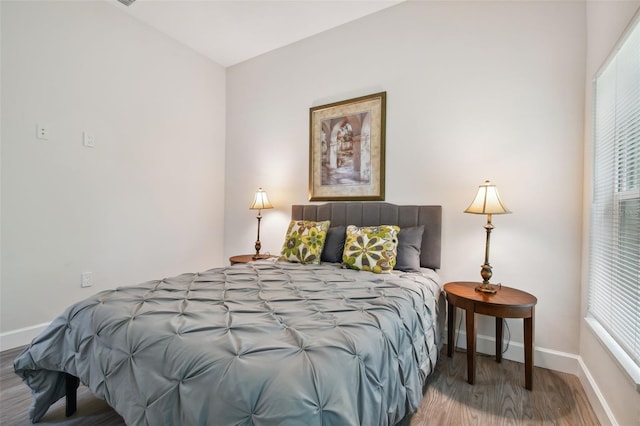 bedroom with wood finished floors and baseboards