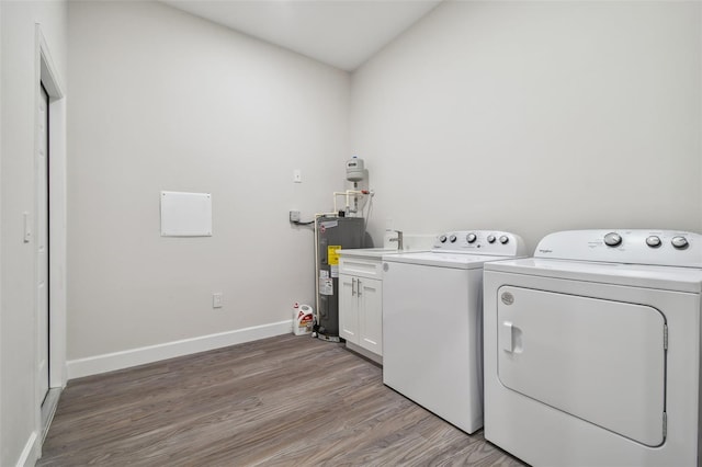 clothes washing area featuring cabinet space, light wood-style flooring, electric water heater, washer and dryer, and baseboards