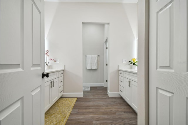 full bathroom featuring baseboards, wood finished floors, and vanity