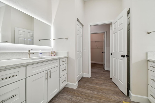 full bathroom featuring vanity, baseboards, and wood finished floors