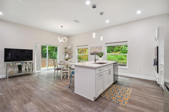 kitchen featuring dark wood-style flooring, decorative light fixtures, white cabinetry, a sink, and dishwasher