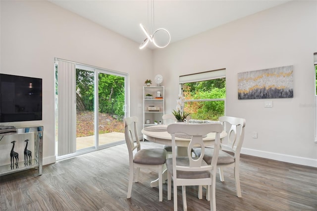 dining area with a notable chandelier, wood finished floors, and baseboards