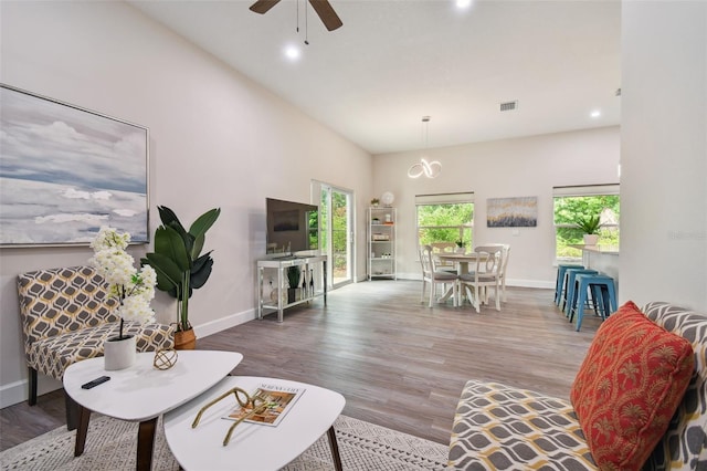 living room featuring baseboards, visible vents, ceiling fan, and wood finished floors