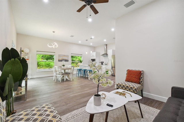 living room with baseboards, visible vents, wood finished floors, and recessed lighting