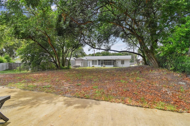 view of yard featuring a sunroom and fence