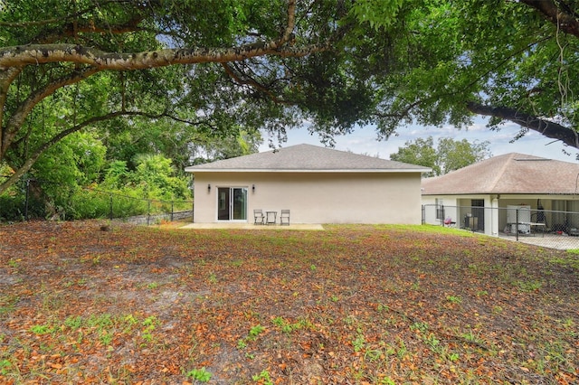 back of property with a fenced backyard and stucco siding