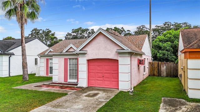 view of front facade with a garage, fence, concrete driveway, stucco siding, and a front yard