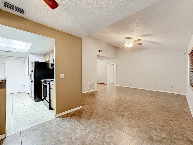 unfurnished living room with vaulted ceiling with skylight, visible vents, and ceiling fan