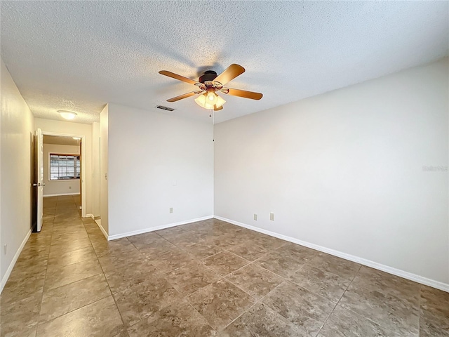 unfurnished room with a textured ceiling, baseboards, visible vents, and a ceiling fan