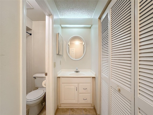 bathroom with tile patterned flooring, toilet, visible vents, vanity, and a closet