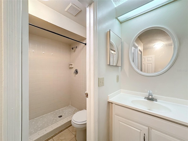 bathroom featuring tile patterned flooring, toilet, vanity, visible vents, and a shower stall