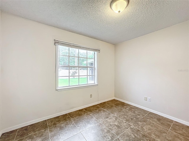 unfurnished room featuring baseboards and a textured ceiling