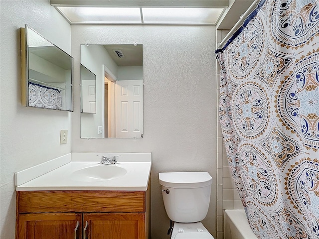 bathroom with toilet, vanity, and visible vents