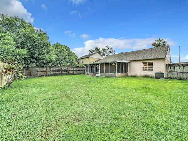 view of yard featuring central AC, a fenced backyard, and a sunroom