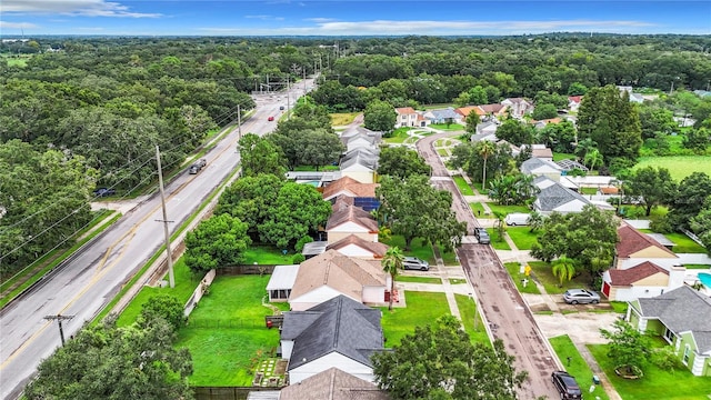 drone / aerial view with a residential view and a wooded view