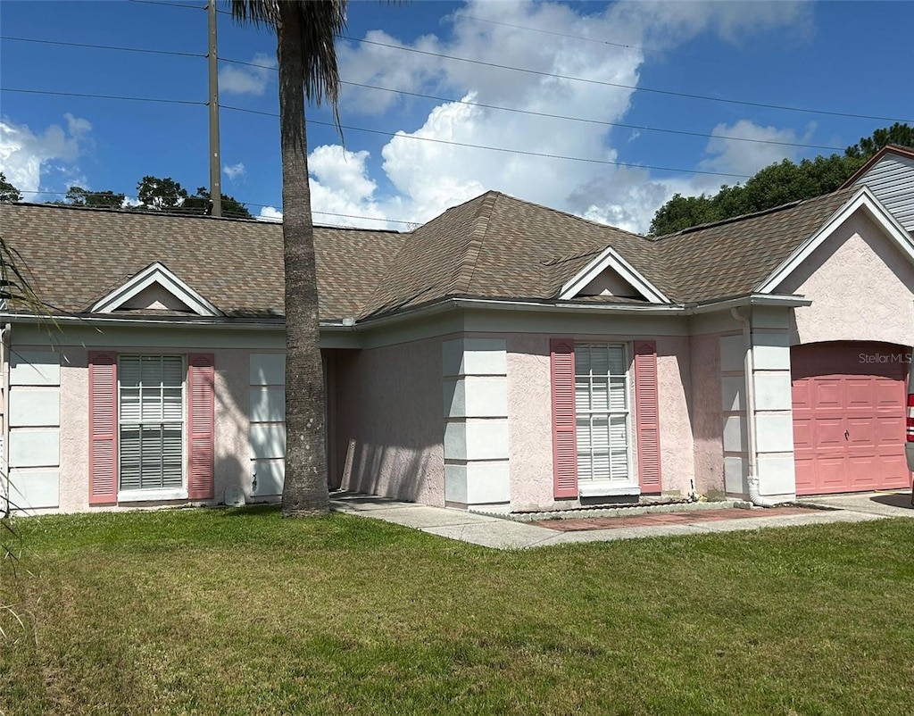 ranch-style house featuring a front yard and stucco siding