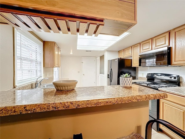 kitchen with tile countertops, black appliances, light brown cabinetry, and a sink