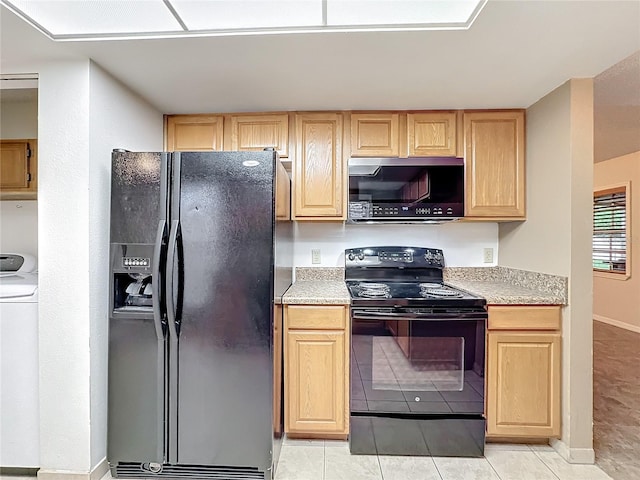 kitchen featuring light tile patterned flooring, light brown cabinets, light countertops, black appliances, and washer / clothes dryer