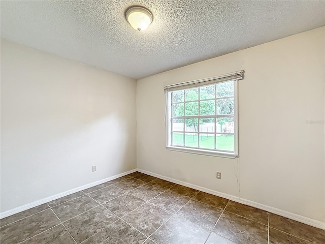 empty room featuring baseboards and a textured ceiling