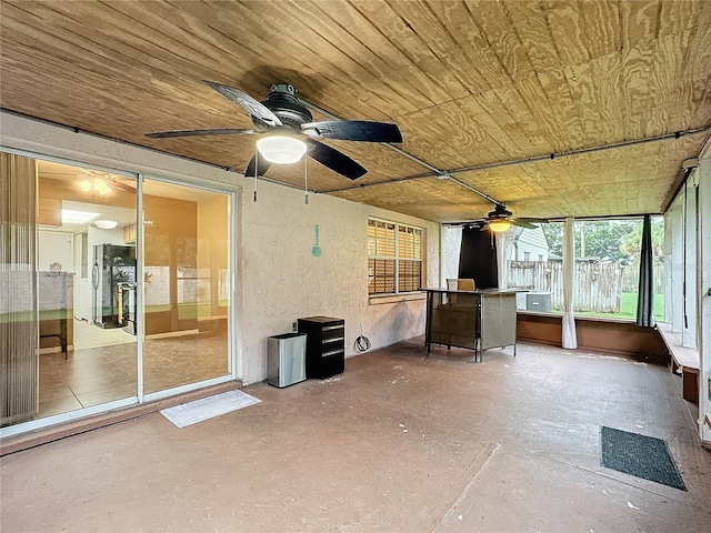 unfurnished sunroom with a ceiling fan and wooden ceiling