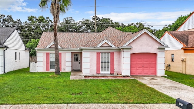 ranch-style home featuring a garage, a front yard, driveway, and stucco siding