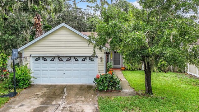 ranch-style home featuring a garage and a front lawn