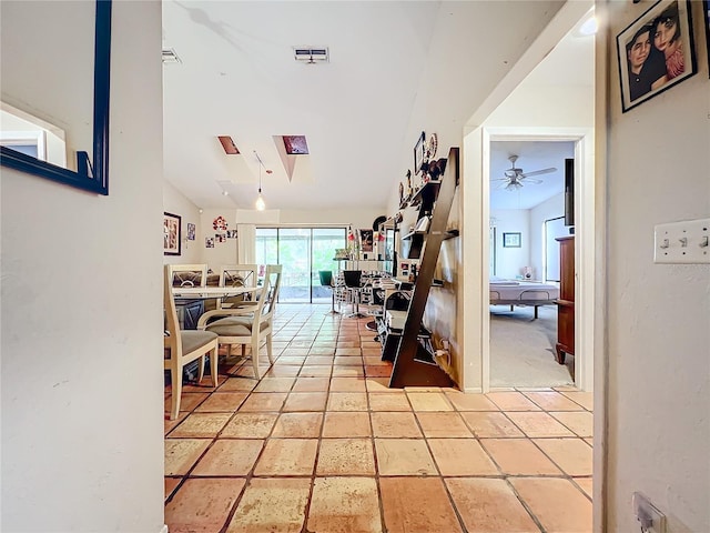 hall featuring visible vents and vaulted ceiling