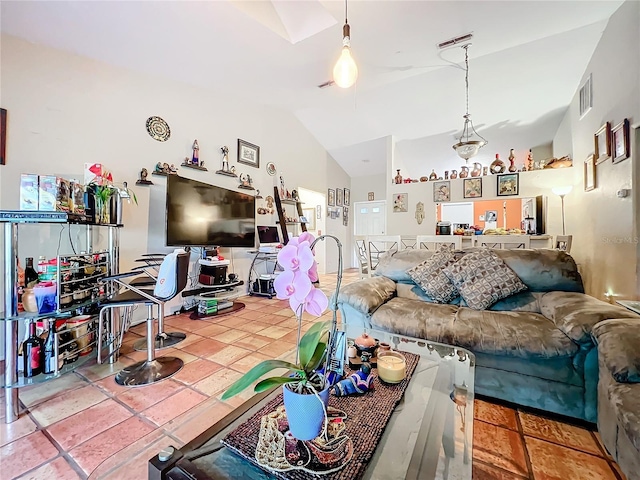 tiled living room with visible vents and vaulted ceiling