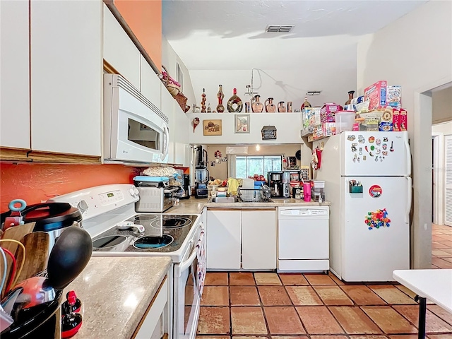 kitchen featuring white appliances, light countertops, visible vents, and white cabinets