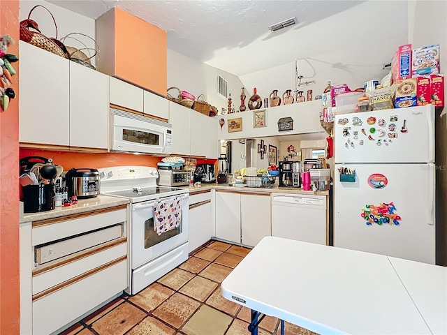 kitchen featuring white appliances, visible vents, white cabinetry, and light countertops