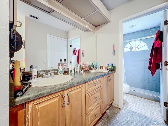 full bath with double vanity, a shower stall, visible vents, and a sink