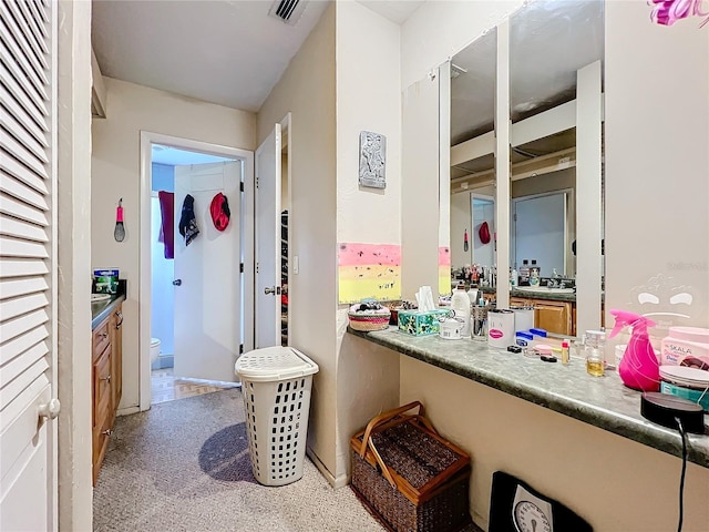 interior space with visible vents, vanity, and toilet