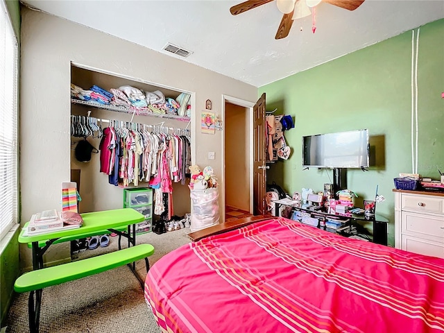 carpeted bedroom with a ceiling fan, a closet, and visible vents