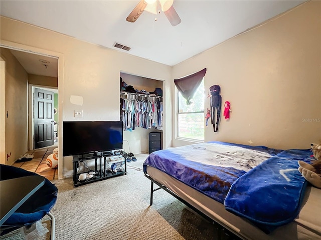 bedroom with light carpet, ceiling fan, a closet, and visible vents