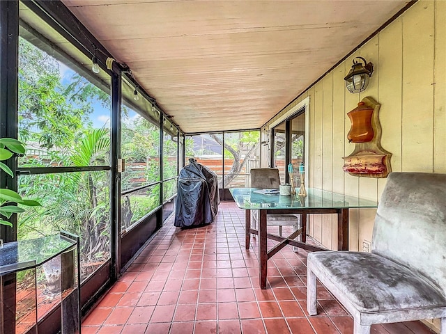 unfurnished sunroom featuring rail lighting