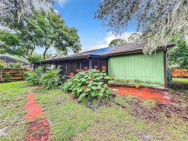 back of property featuring fence and a sunroom