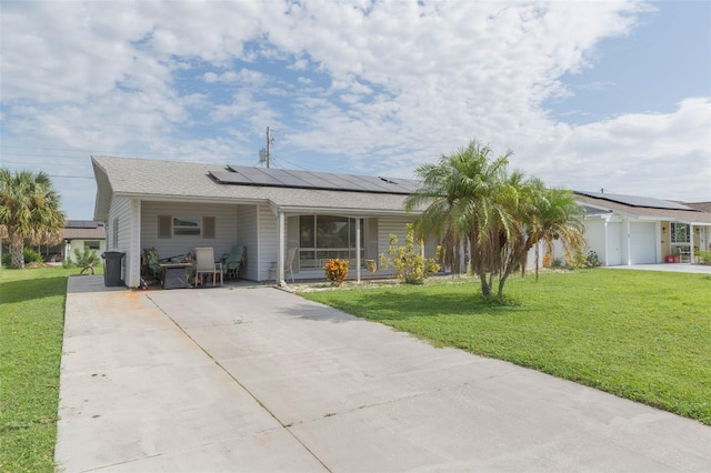 single story home with solar panels, a garage, and a front lawn