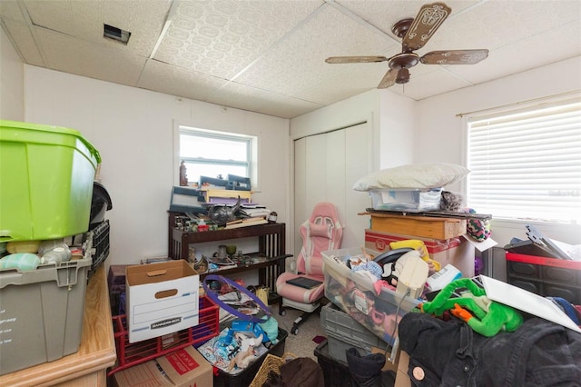 miscellaneous room featuring ceiling fan, carpet, and a paneled ceiling