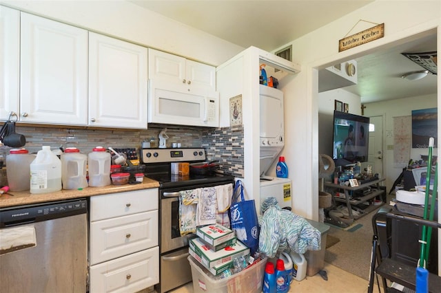 kitchen with white cabinetry, appliances with stainless steel finishes, stacked washer / dryer, and decorative backsplash