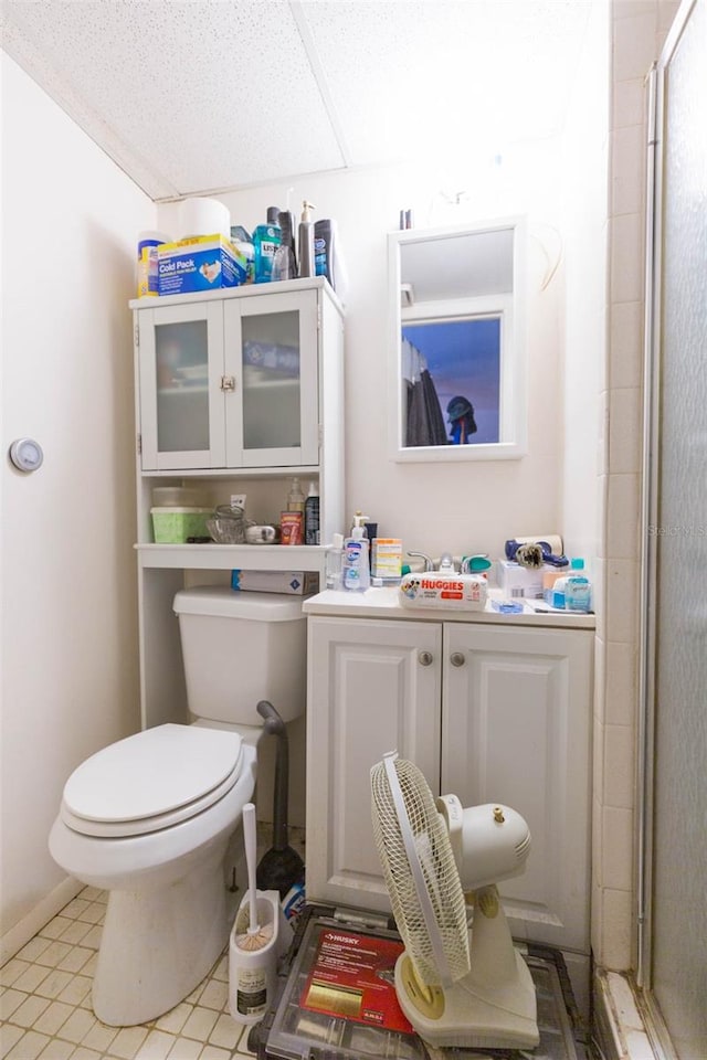 bathroom featuring a shower with shower door, toilet, tile patterned flooring, and vanity