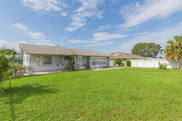 rear view of house featuring a lawn and a patio area