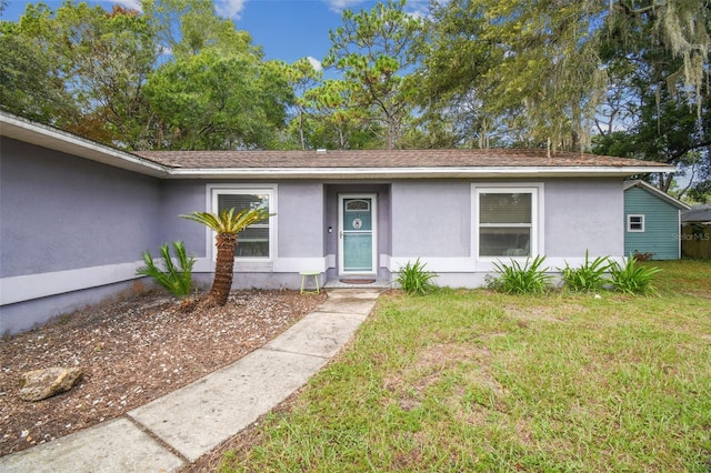 view of front of home featuring a front yard and stucco siding