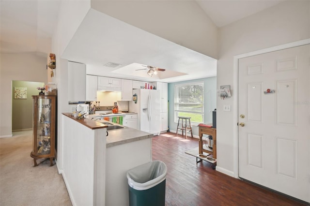 kitchen with kitchen peninsula, ceiling fan, white refrigerator with ice dispenser, dark hardwood / wood-style floors, and white cabinetry