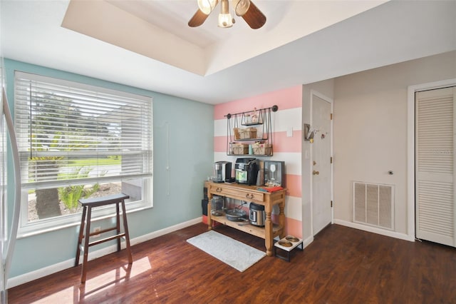 misc room featuring dark hardwood / wood-style floors, ceiling fan, and a tray ceiling