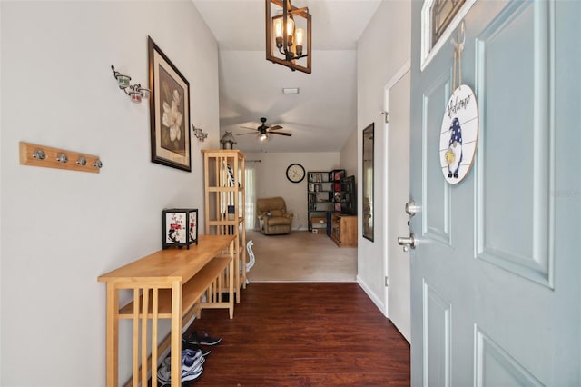 entrance foyer with ceiling fan with notable chandelier and dark wood-type flooring