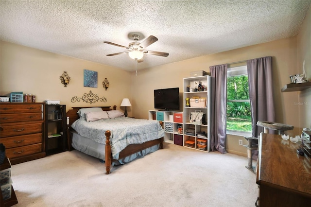 bedroom featuring a textured ceiling, light colored carpet, and ceiling fan