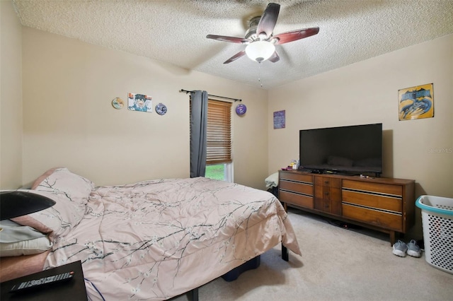 bedroom featuring ceiling fan, light colored carpet, and a textured ceiling