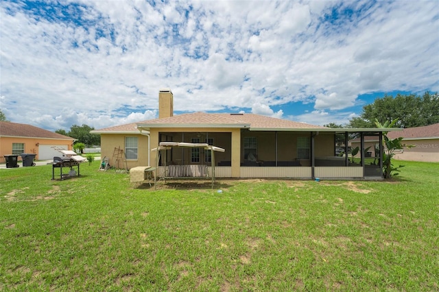 back of house with a sunroom and a yard