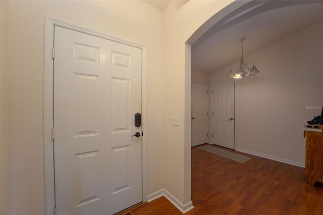 entrance foyer featuring vaulted ceiling, an inviting chandelier, and hardwood / wood-style floors