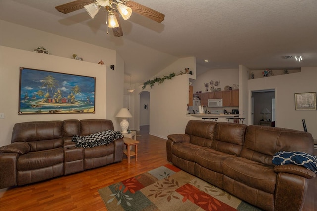 living room with hardwood / wood-style floors, vaulted ceiling, and ceiling fan